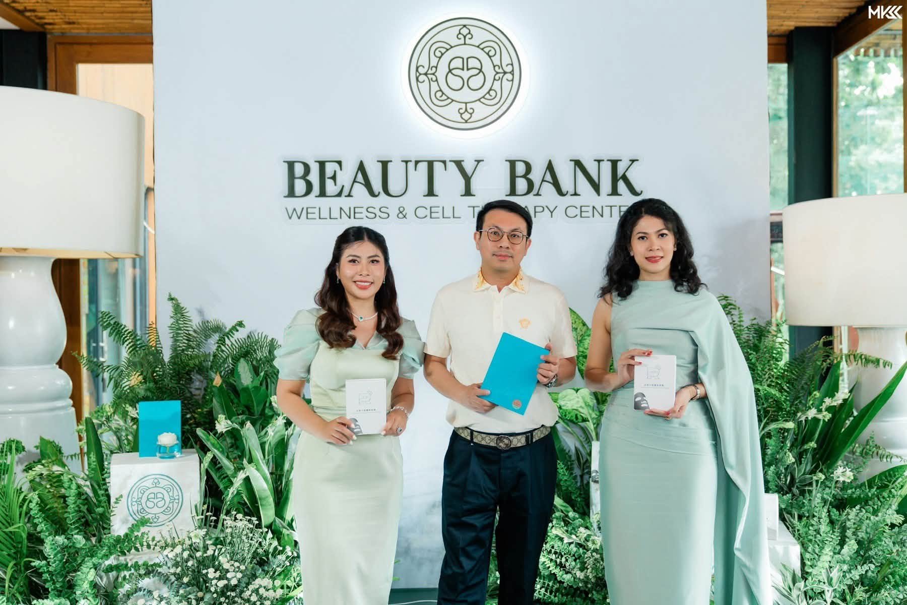Dr. Tony Su with the Beauty Bank founding principals in front of the brand backdrop, holding presentation gifts from the ceremony.
