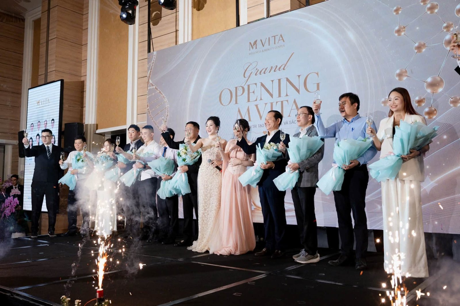 The M VITA founding team on stage during the toast, in front of the ‘Grand Opening MVITA’ backdrop.